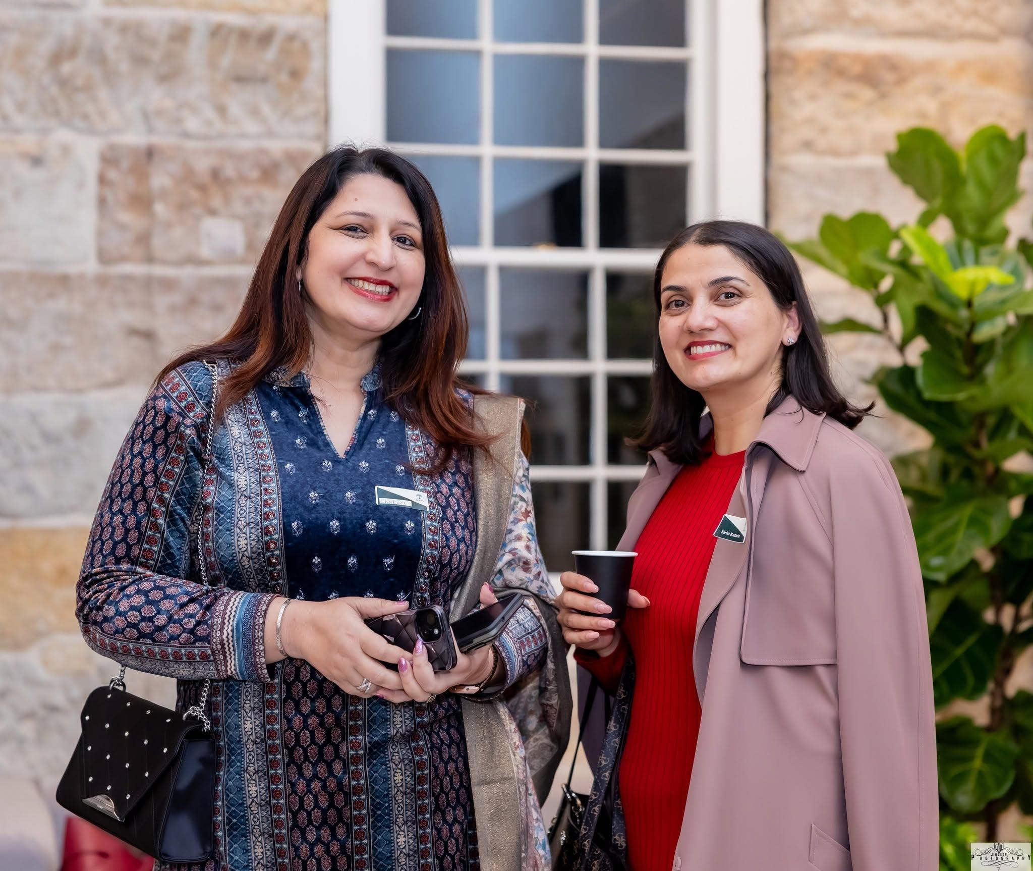 Two members sharing a coffee and a laugh in the courtyard at an Artha gathering