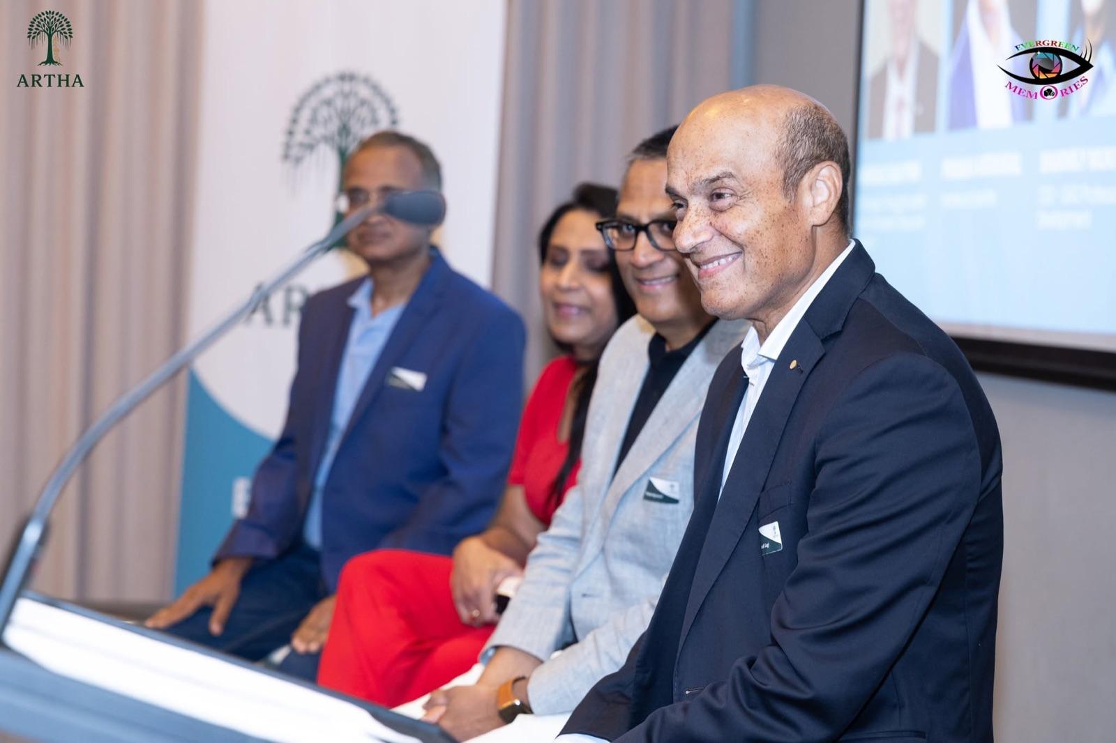 Artha co-founders on the panel at the Soft Launch Event, with the Artha banner behind them.